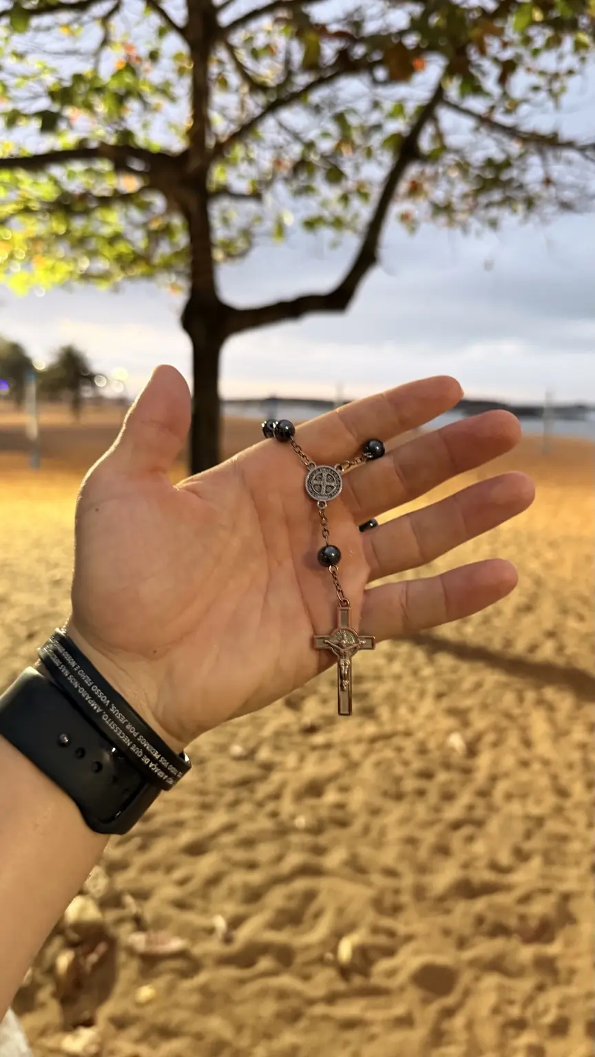 Terço na mão durante o amanhecer